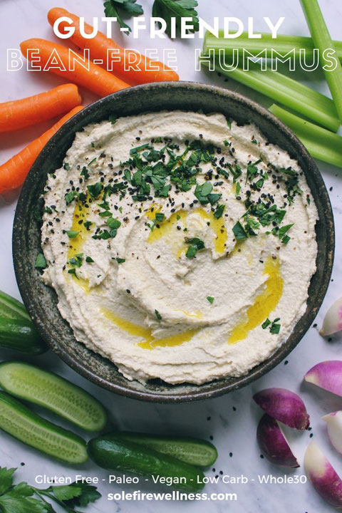 A handmade bowl filled with bean-free paleo hummus and colorful veggies